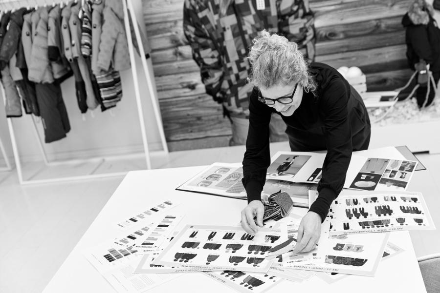 A designer reviewing clothing designs and fabric samples
